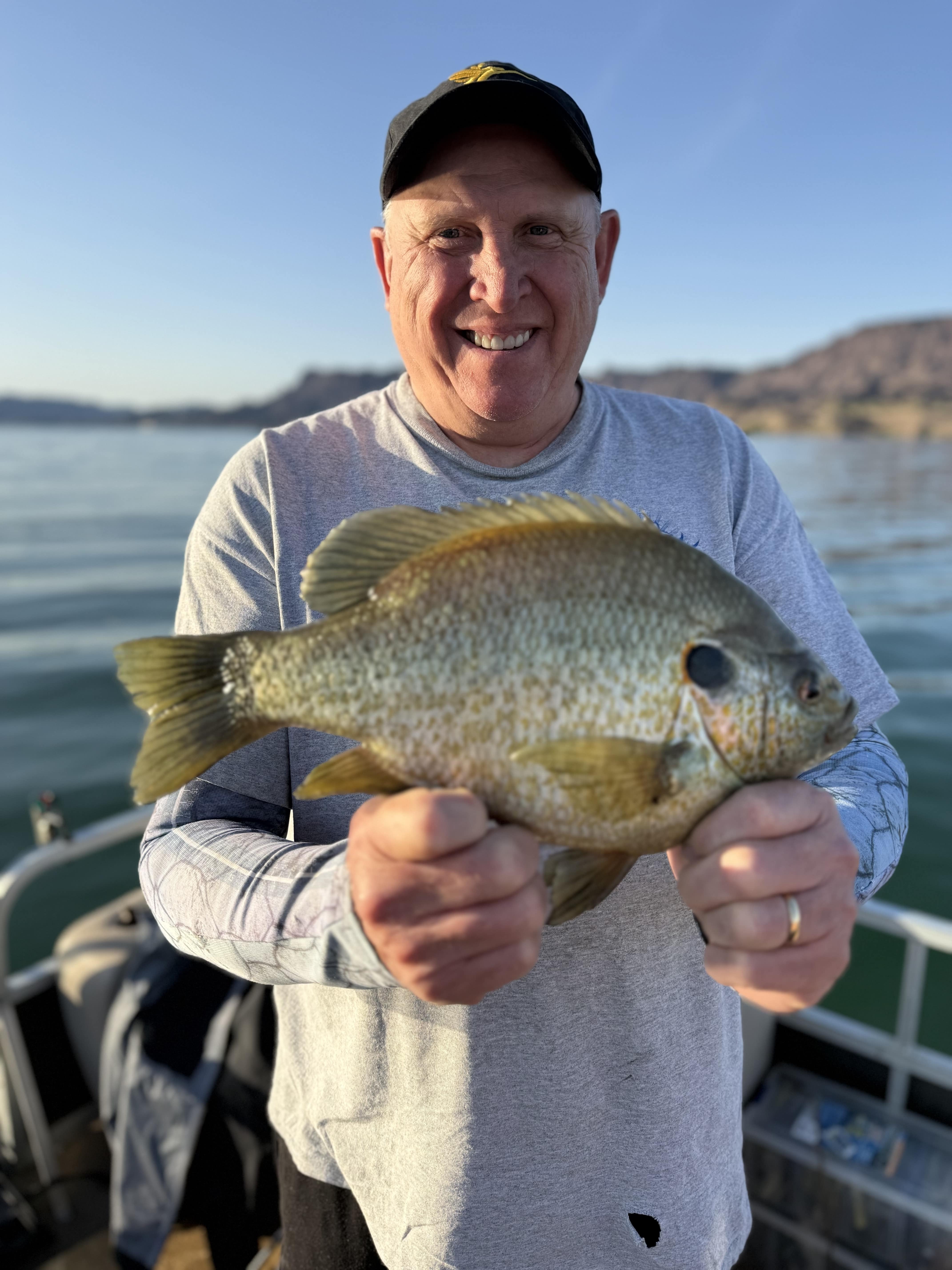 Angler holding a redear sunfish on the boat
