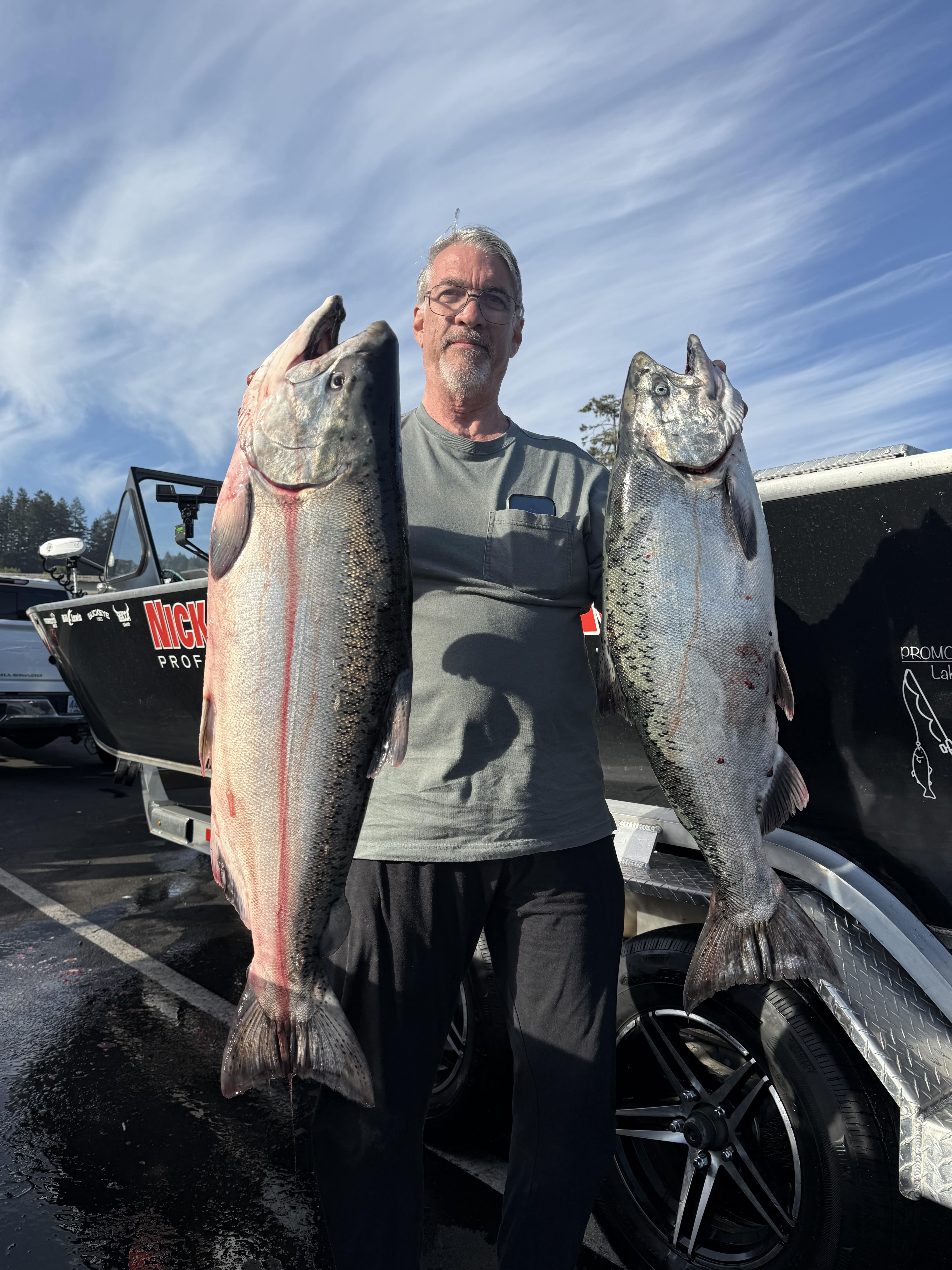 Striped bass being held up on the deck of the boat