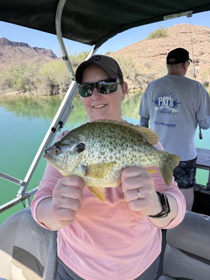Angler holding a redear sunfish on Lake Havasu under bimini shade